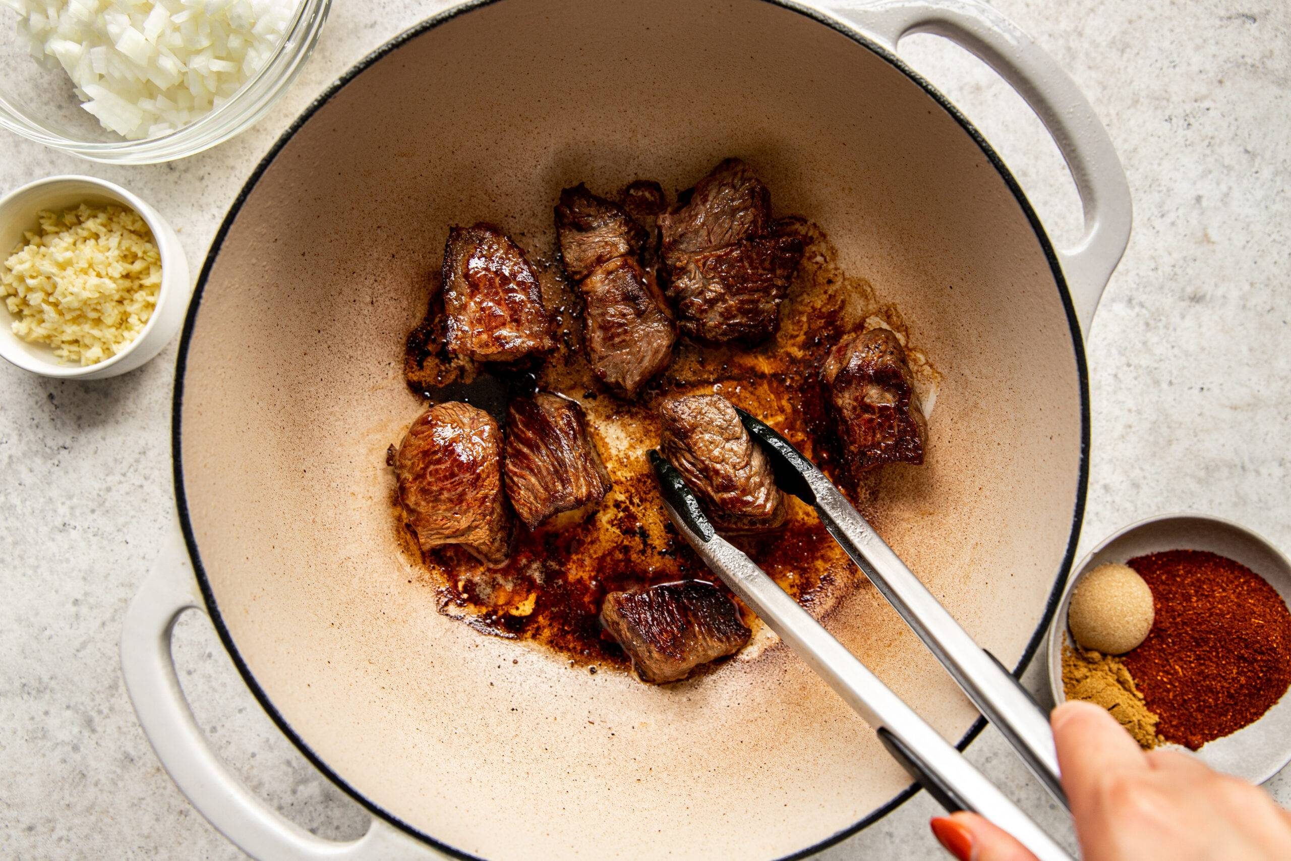 Browning beef in a pot.