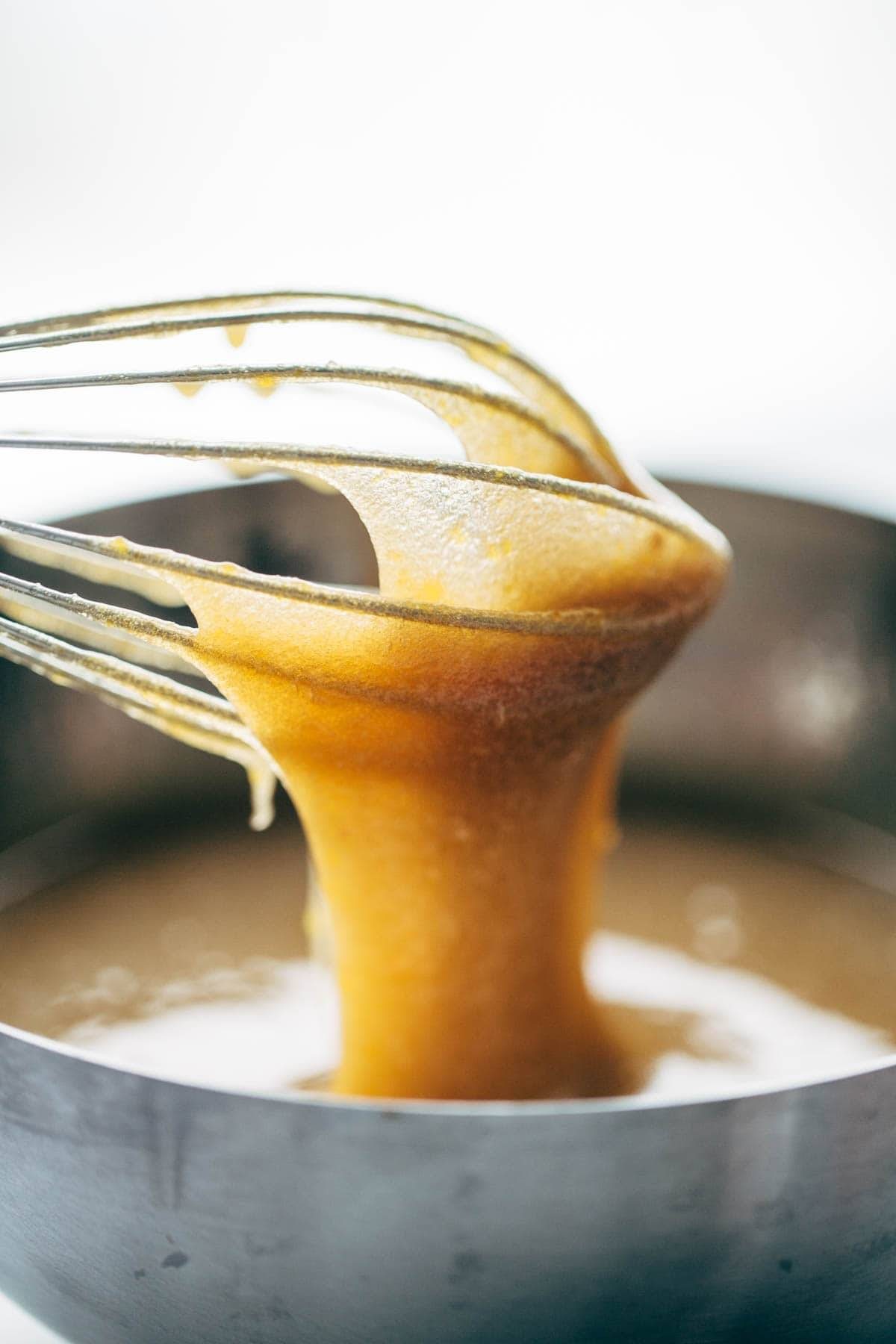 Lemon Poppyseed Zucchini Bread batter in a bowl and on a whisk.