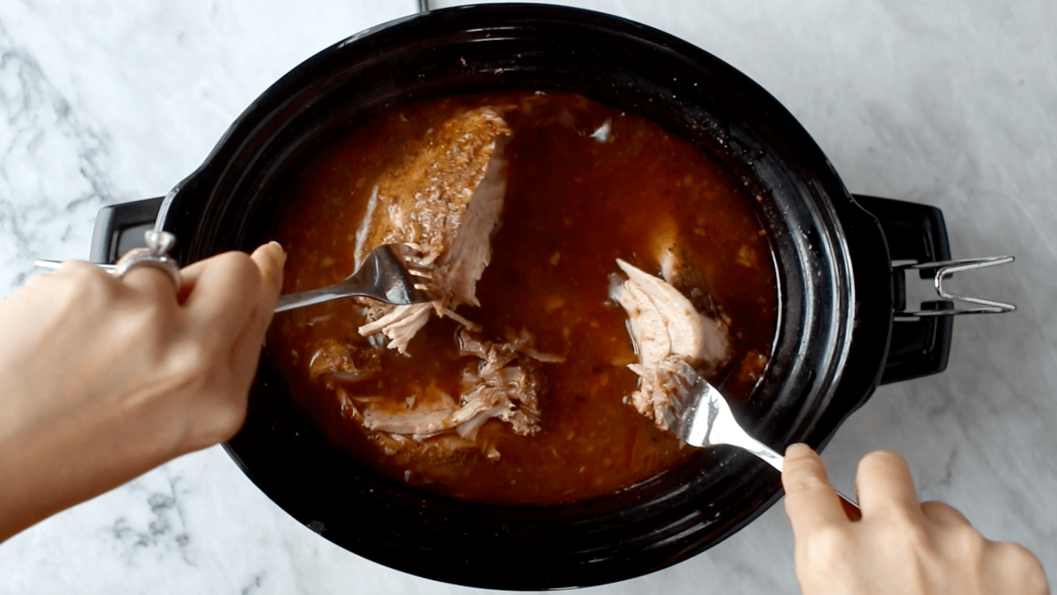 Shredding pork in a crockpot.