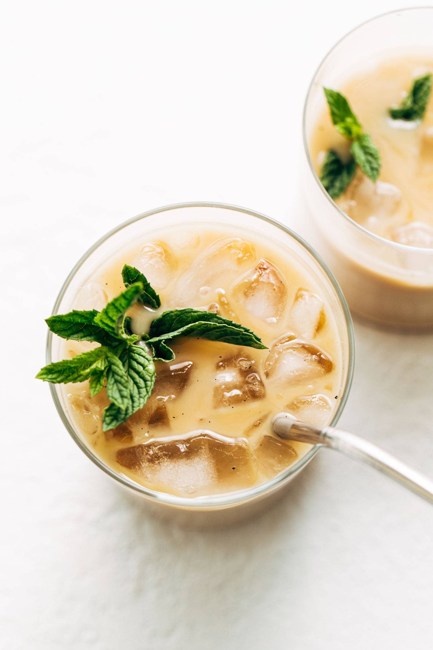 Vanilla mint iced coffee in a glad with ice and mint sprigs.