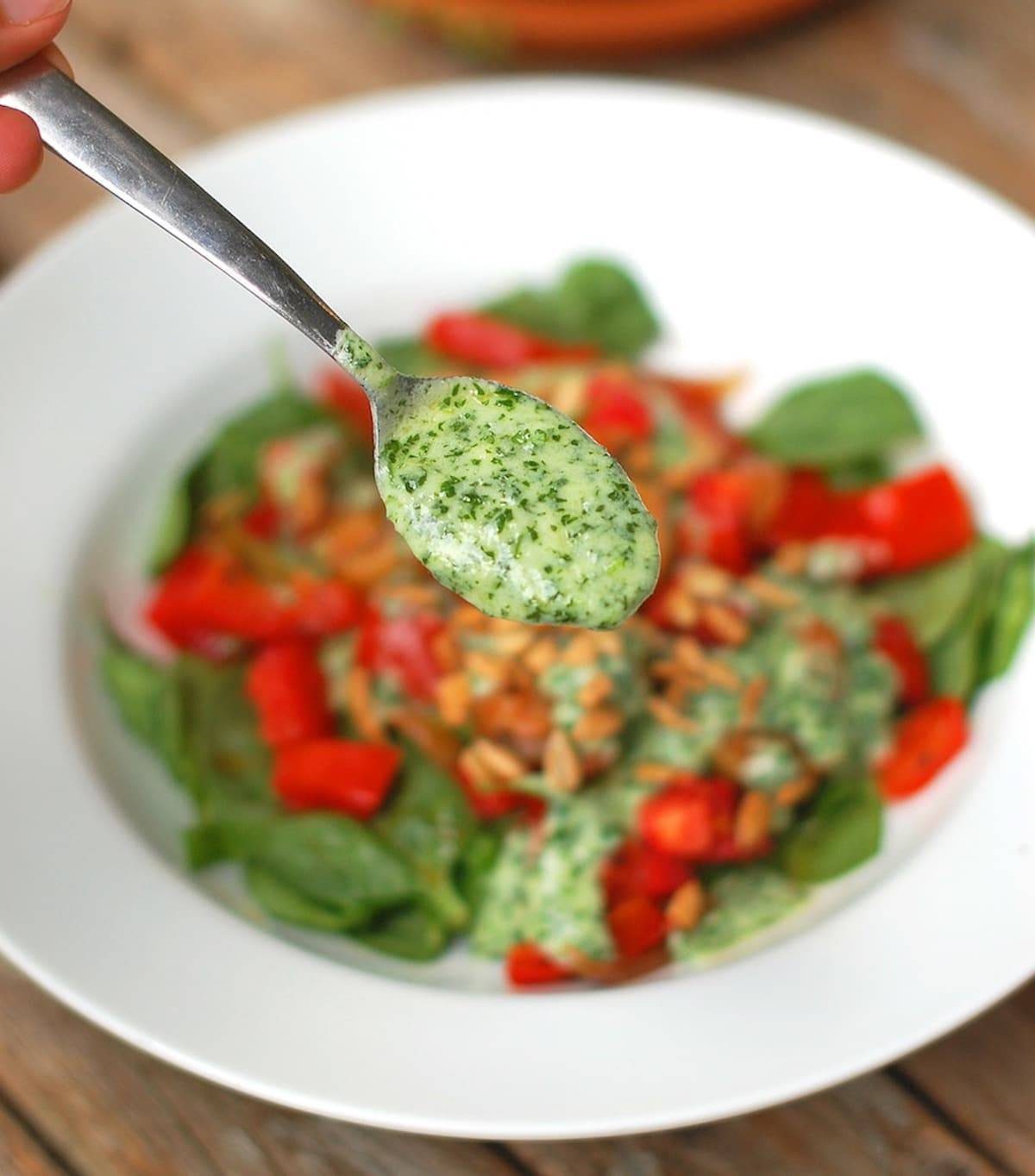 Creamy cilantro dressing on a salad and on a spoon.