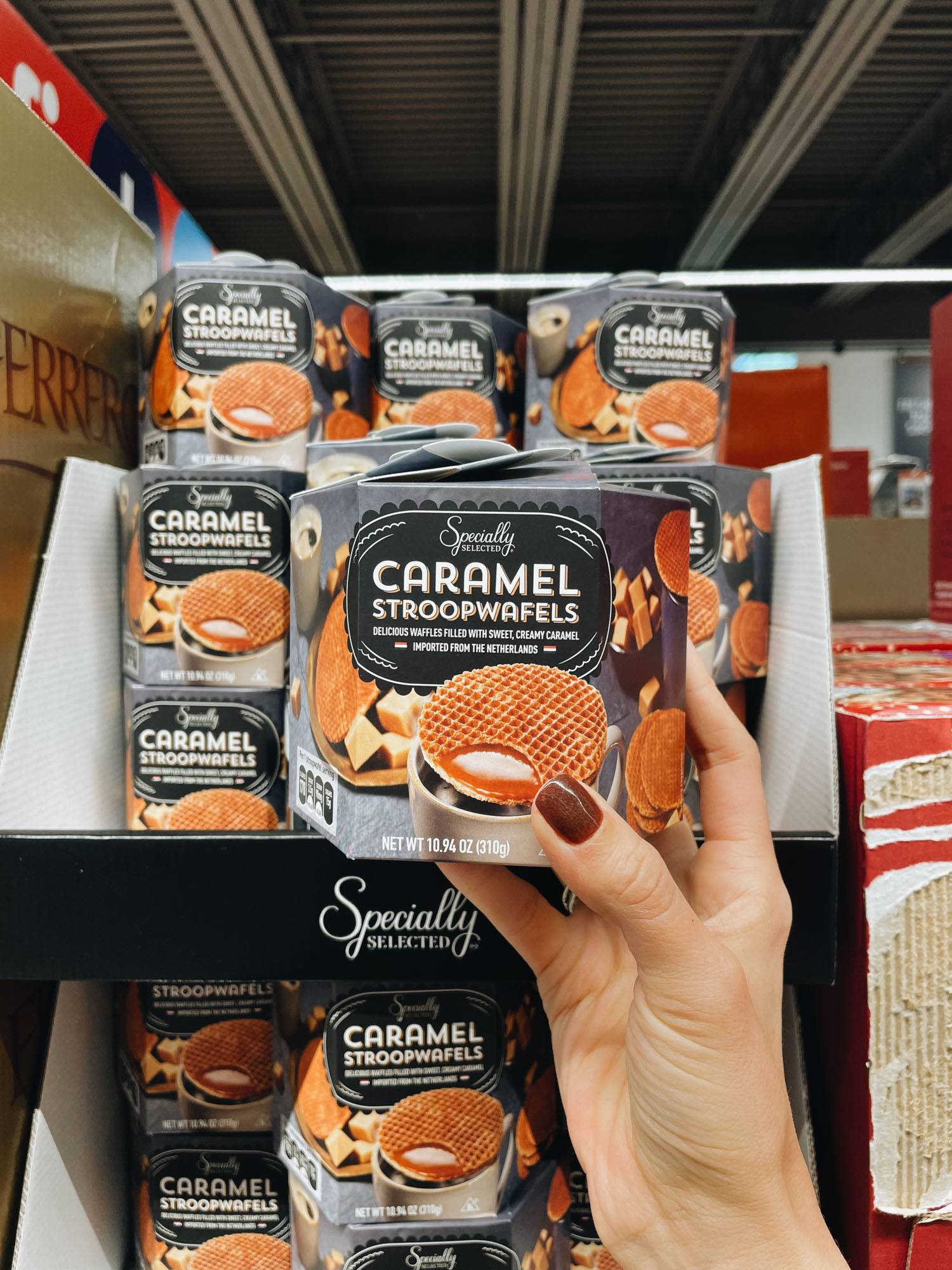 White hand holding caramel stroopwafels