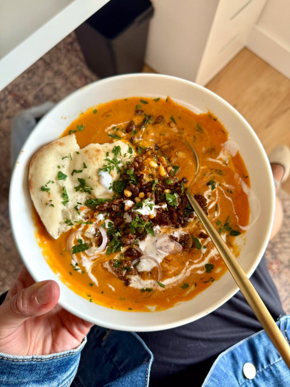 Carrot soup in a bowl with ground beef on top.