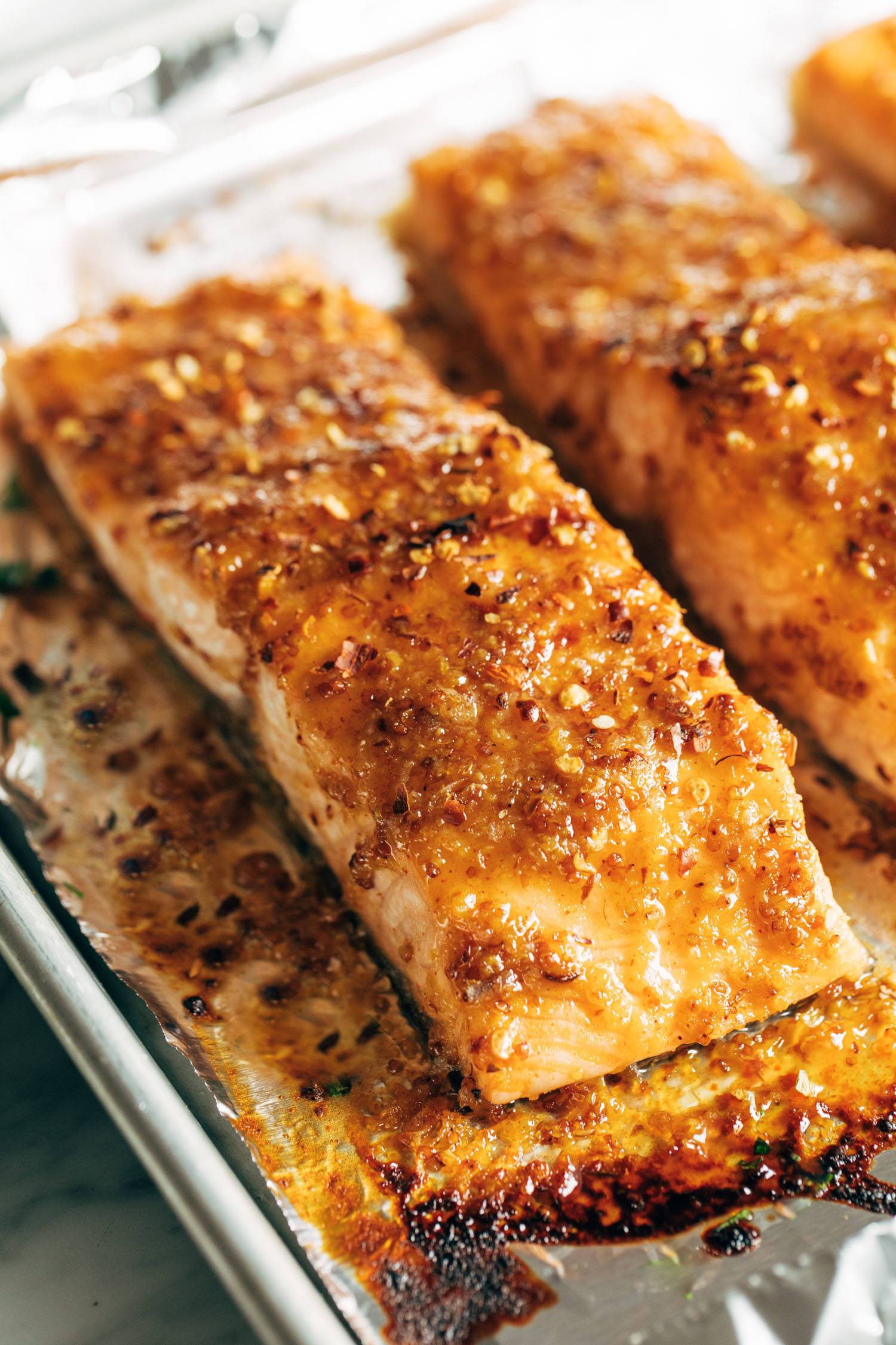 Hot honey salmon on a sheet pan lined with foil.