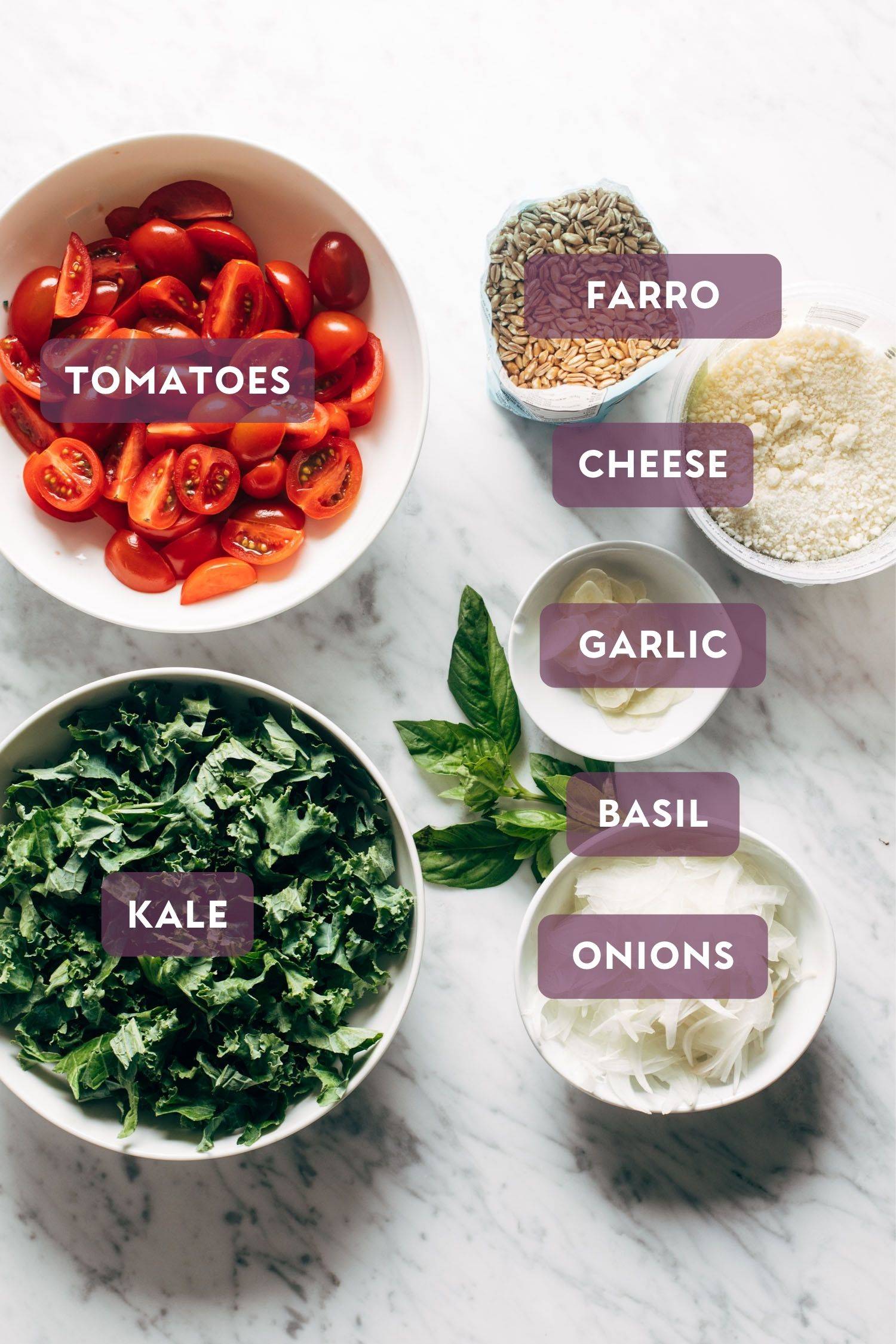 Ingredients for one-pan farro with tomatoes and kale. Ingredients have text over them in purple bubbles.